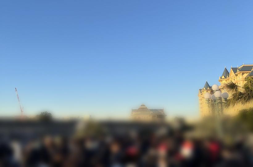 早朝の東京ディズニーランド入園待ち列。奥にディズニーランドホテルとJR舞浜駅